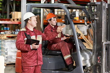 warehouse workers in front of forklift