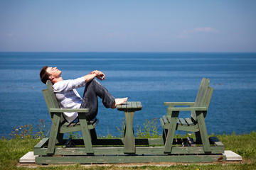 Fototapeta premium Young man sitting on the bench