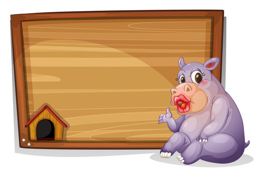 A hippopotamus sitting beside a blank wooden board