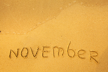 November - written in sand on beach texture