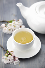 Obraz na płótnie Canvas Cup of green tea and japanese cherry blossom