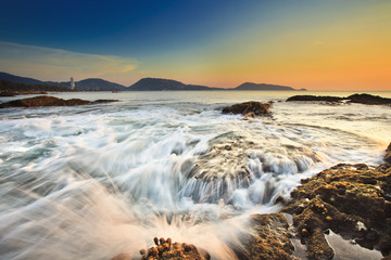 Sea waves lash line impact rock on the beach