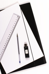 przbory biurowe z czarną teczką na biurku