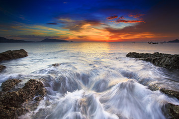 Sea waves lash line impact rock on the beach
