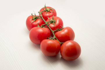 vine tomatoes on a table white