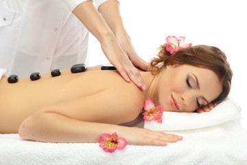 Obraz na płótnie Canvas beautiful young woman in spa salon getting massage with spa