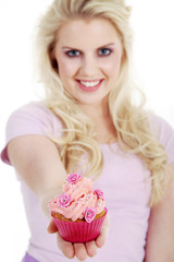 Obraz na płótnie Canvas Junge Frau überreicht lächelnd Cupcake