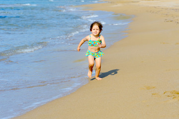 Fototapeta premium Happy toddler girl running on the beach