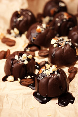 Chocolate candies and coffee beans, on beige paper background