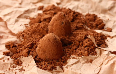 Chocolate truffles and cocoa, on brown background