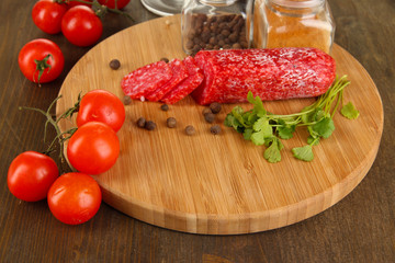 Tasty salami on board wooden table close-up