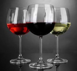 Assortment of wine in glasses on grey background