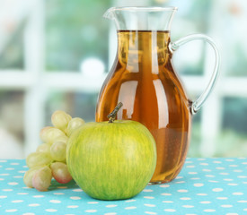 Apple juice in pitcher on table in room