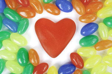 Sweet heart surrounded by colorful candies background.