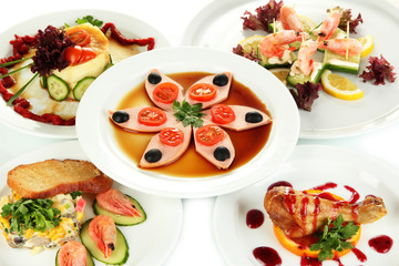 Small portions of food on big white plates close up