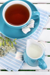 Beautiful tea composition on wooden picnic table close-up