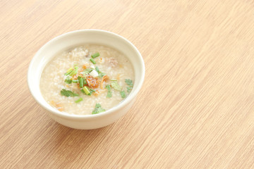 Congee bowl on wood texture tile floor.