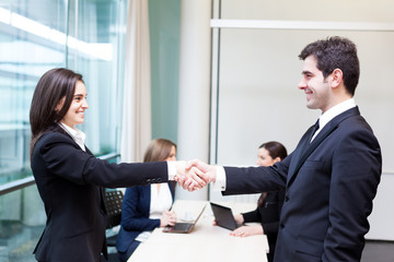 Business people shaking hands in the office, finishing a meeting