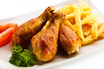 Grilled chicken drumsticks with chips and vegetables