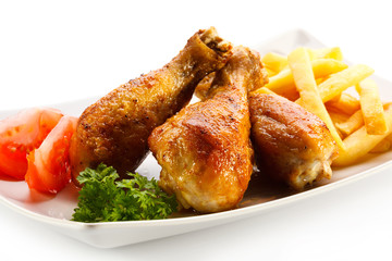Grilled chicken drumsticks with chips and vegetables