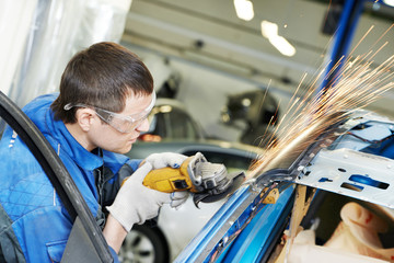repairman grinding metal body car