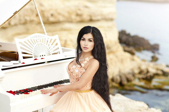 Beautiful bride in wedding dress with piano outdoors