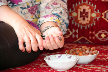 Obraz na płótnie Canvas Woman hand cracking a nut with nutcracker