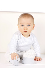 Fototapeta premium süßes Baby sitzt an einer Wand - sweet baby sitting