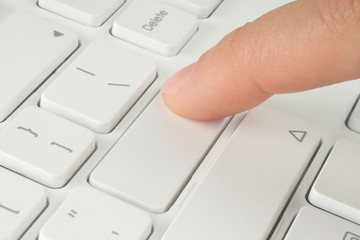 Hand pushing the button of keyboard .