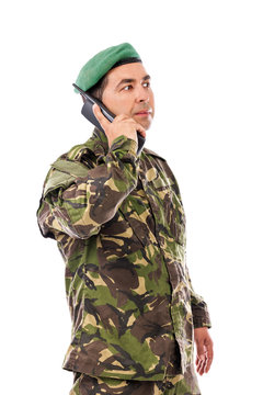 Young army soldier with beret speaking on phone