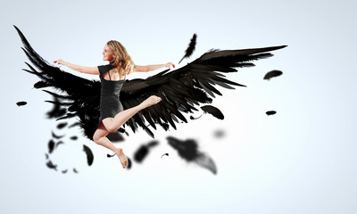 Woman floating   on dark wings