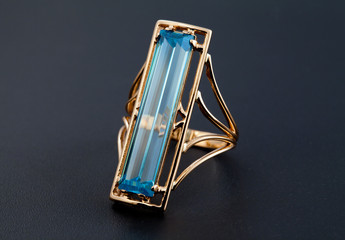 Golden jewelry ring with blue topaz