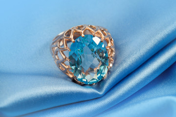 Golden jewelry ring with blue topaz