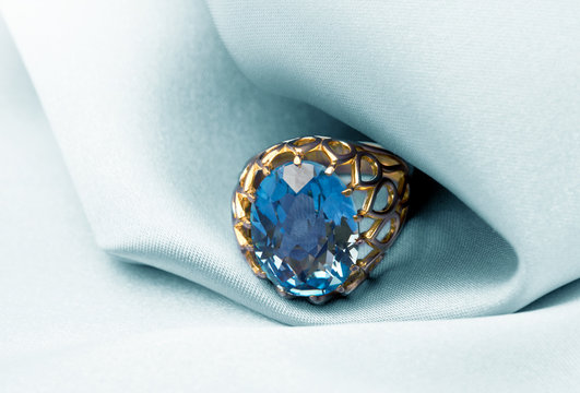 Golden jewelry ring with blue topaz