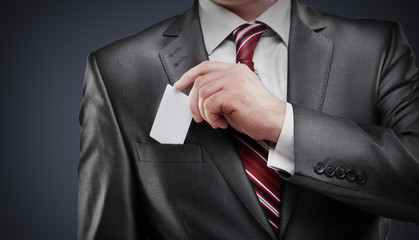 Business man handing a blank business card isolated on gray background High resolution