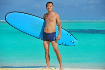 Man with surf board on beach