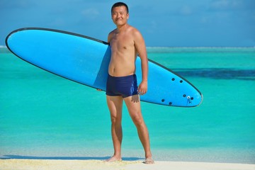 Man with surf board on beach