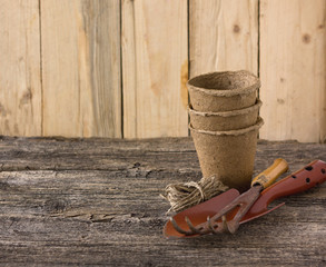 peat pots and garden tools on a wooden board