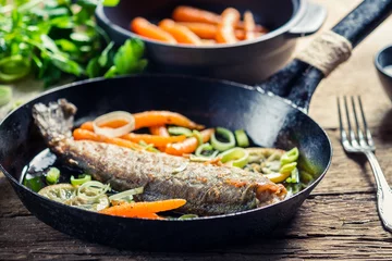 Crédence de cuisine en verre imprimé Poisson Closeup of freshly fried fish with lemon and carrots