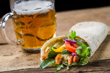 Kebab served with cold beer on old wooden table