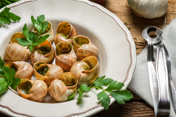Closeup of snails baked in garlic butter and served with parsley