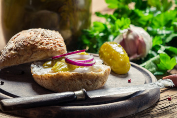 Closeup of a sandwich with onion, pickled cucumber and lard