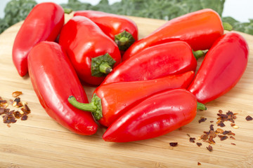 Red hot peppers on wooden cutting board.