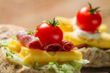 Closeup of sandwich with salami, tomato, cheese and lettuce