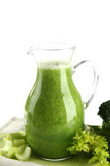 Glass pitcher of green vegetable juice isolated on white
