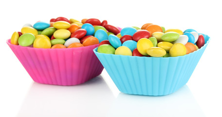 Colorful candies in cupcake cases isolated on white