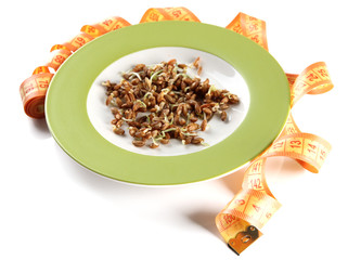 Wheat germs on plate and measuring tape isolated on white