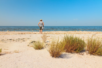 Woman standing at Salton sea. USA. California.