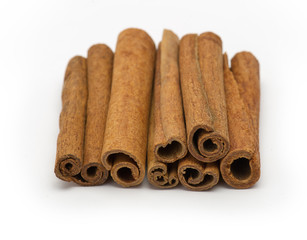 cinnamon sticks stacked on white background