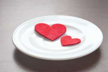 Naklejka na ściany i meble Red hearts on a plate